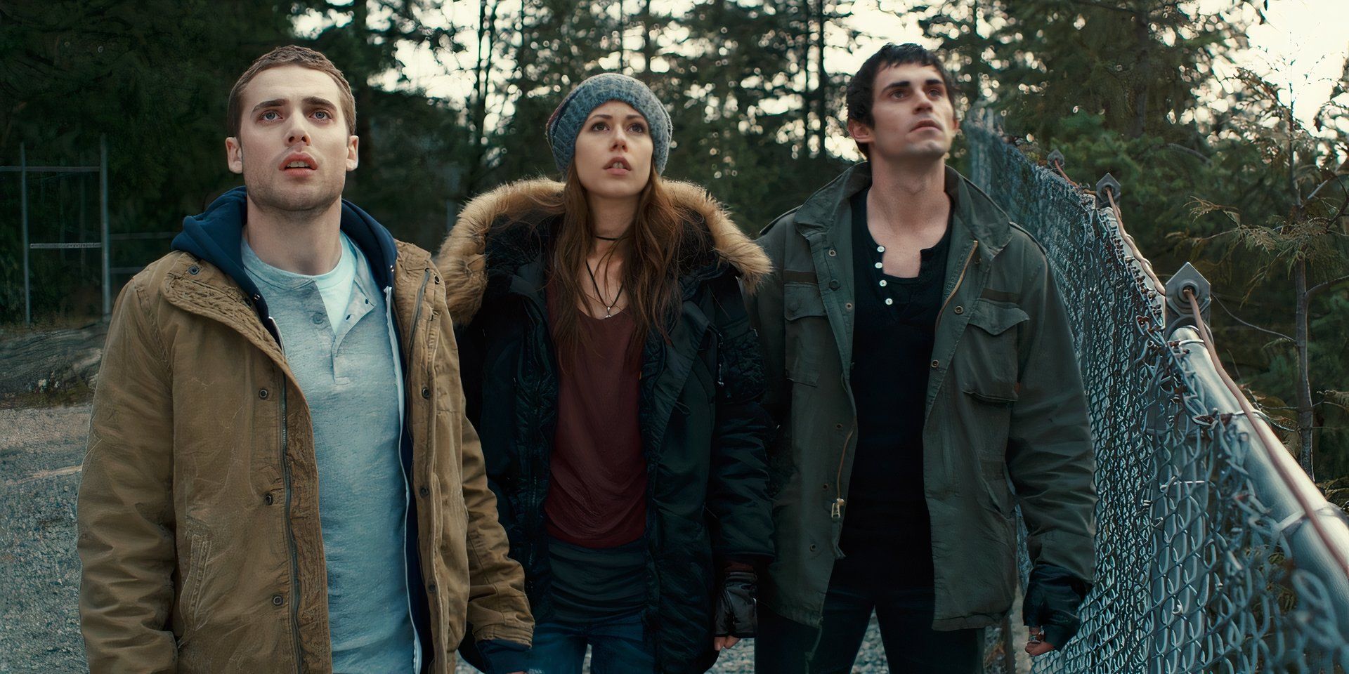 A trio of people wearing winter jackets outside near a chain link fence in &lsquo;Repeaters&rsquo; (2010)