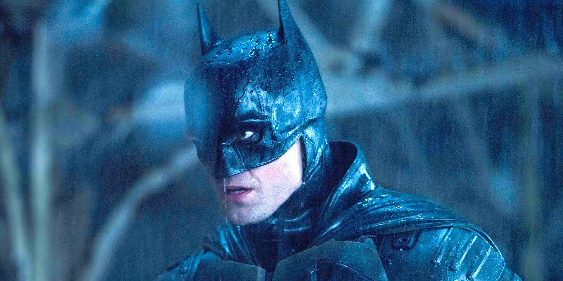 Batman stands menacingly in the pouring rain in The Batman.