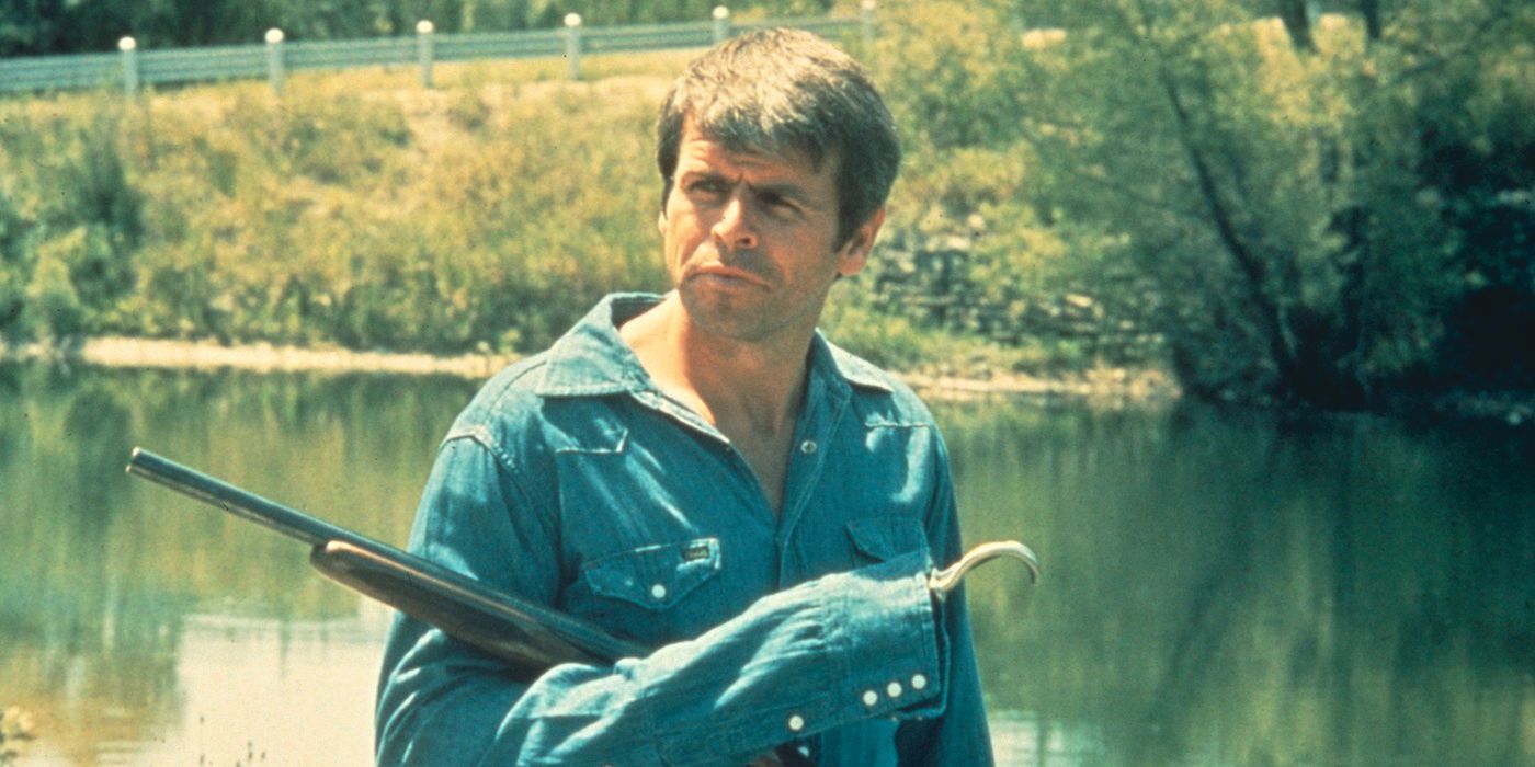 Charles Rane standing by a river holding a rifle in 'Rolling Thunder'