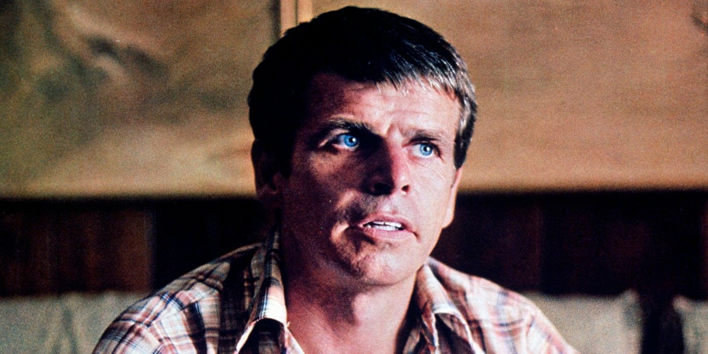 William Devane as Charles Lane sitting and looking up in 