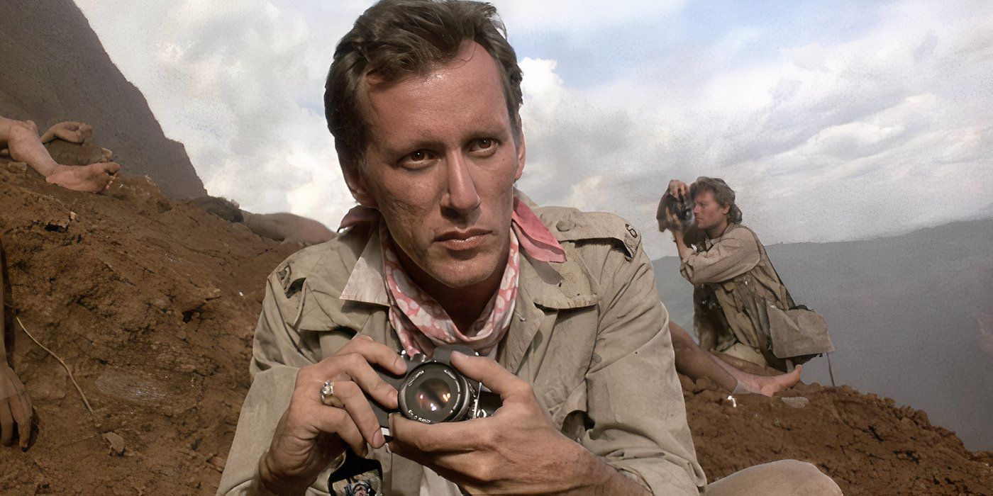 Richard Boyle holding a camera and looking ahead in 'Salvador'