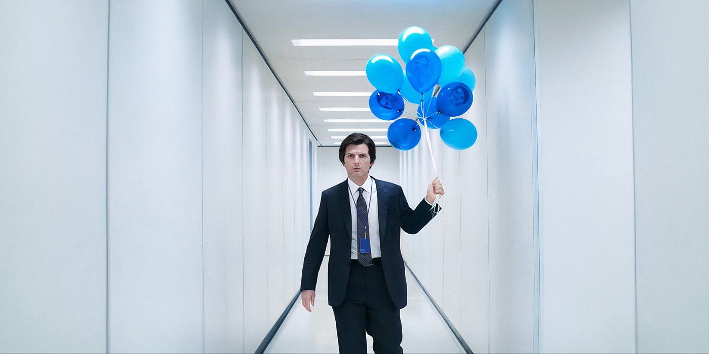 Adam Scott como Mark S. En la temporada 2 de Severance vistiendo un traje y sosteniendo un ramo de globos azules en un pasillo blanco.