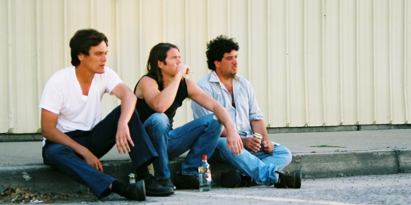 Three people sitting next to each other on a sidewalk in &lsquo;Shotgun Stories&rsquo;