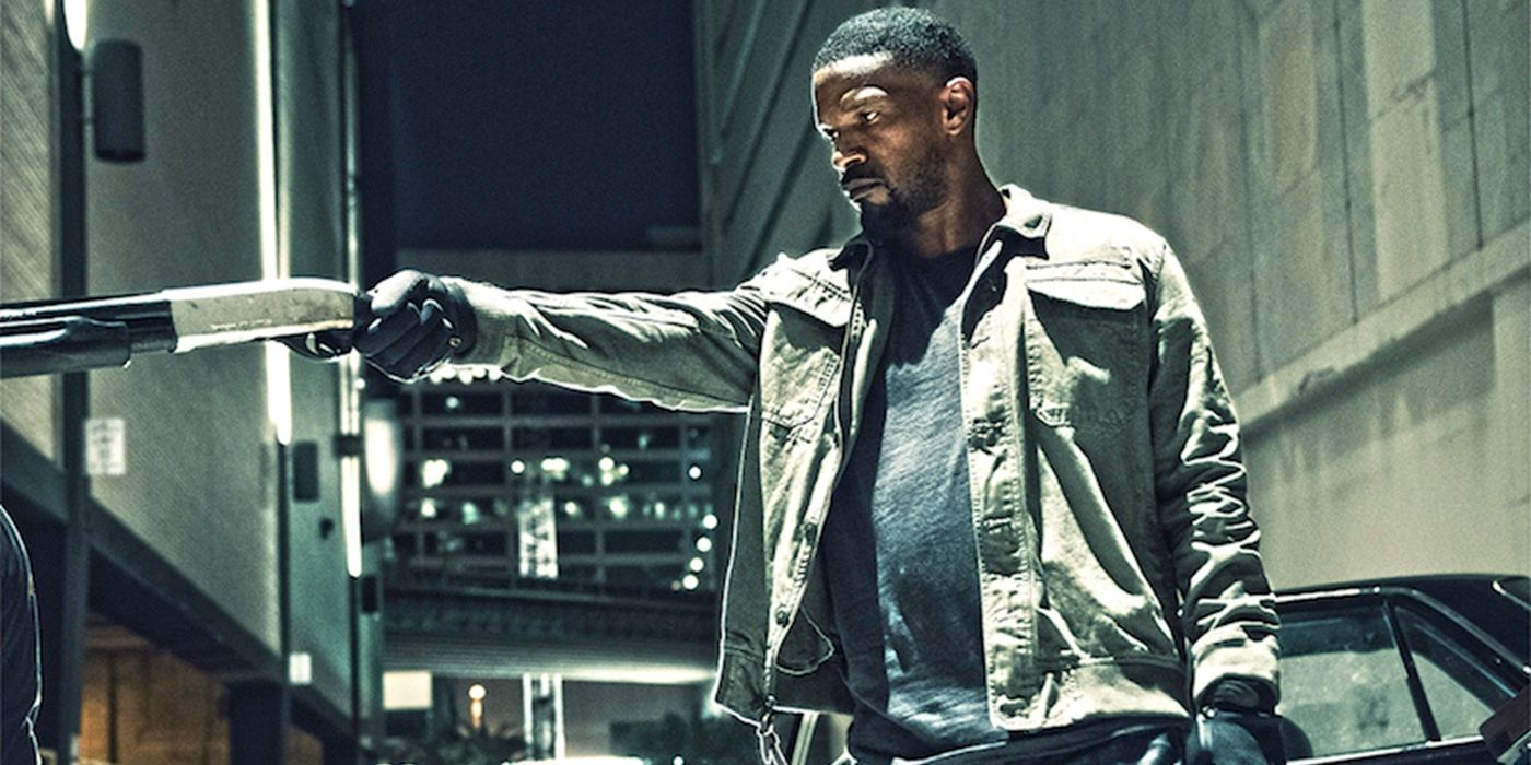 Jamie Foxx as Vincent Downs pointing a rifle at a person in Sleepless
