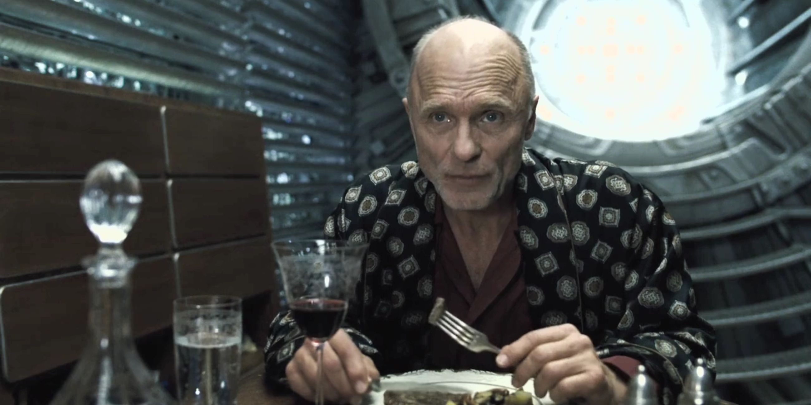 Ed Harris as Wilford eating dinner in Snowpiercer