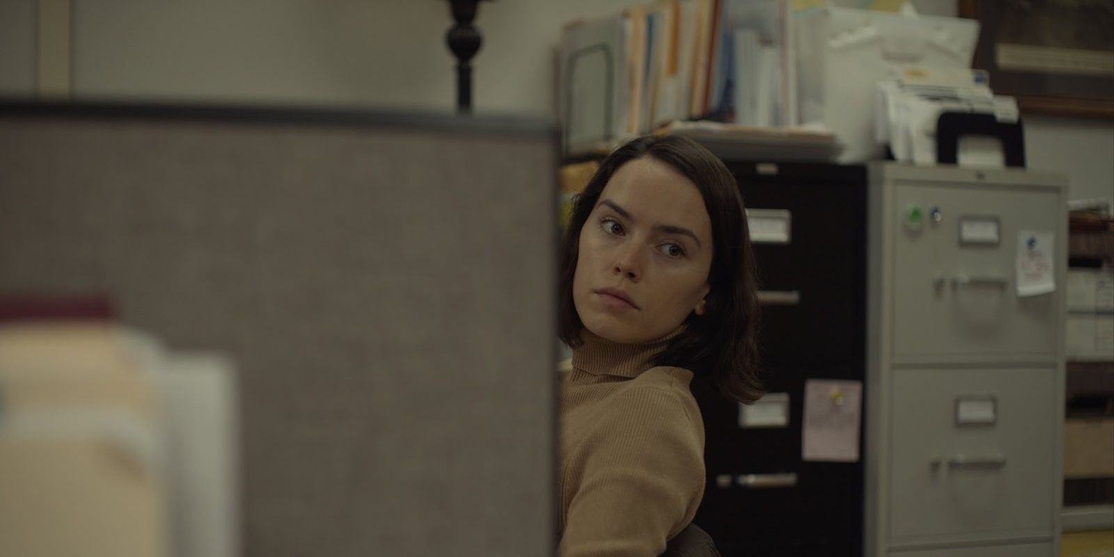 Daisy Ridley as Fran looking at something from her cubicle in Sometimes I Think About Dying