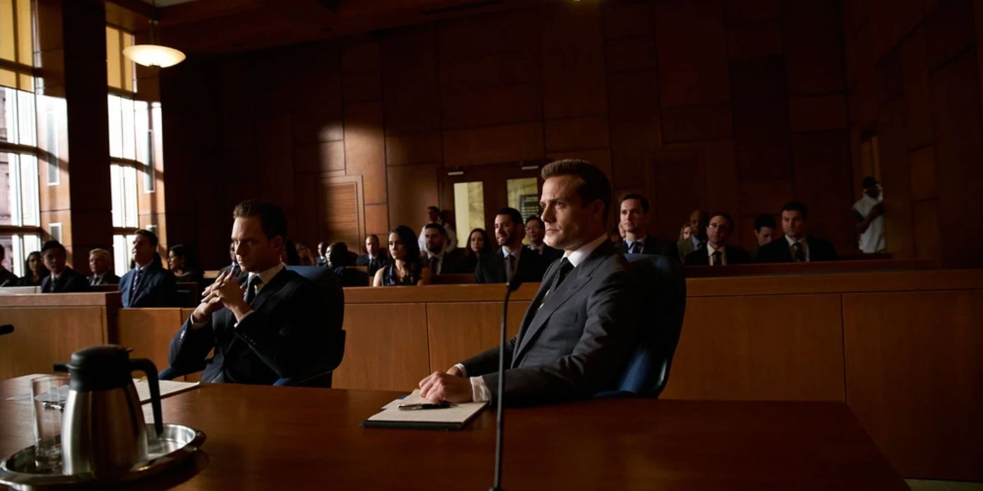 Mike Ross (Patrick J. Adams) and Harvey Specter (Gabriel Macht) sit in a packed courtroom in &lsquo;Suits&rsquo; Season 5, Episode 15 &ldquo;Tick Tock&rdquo; (2016).