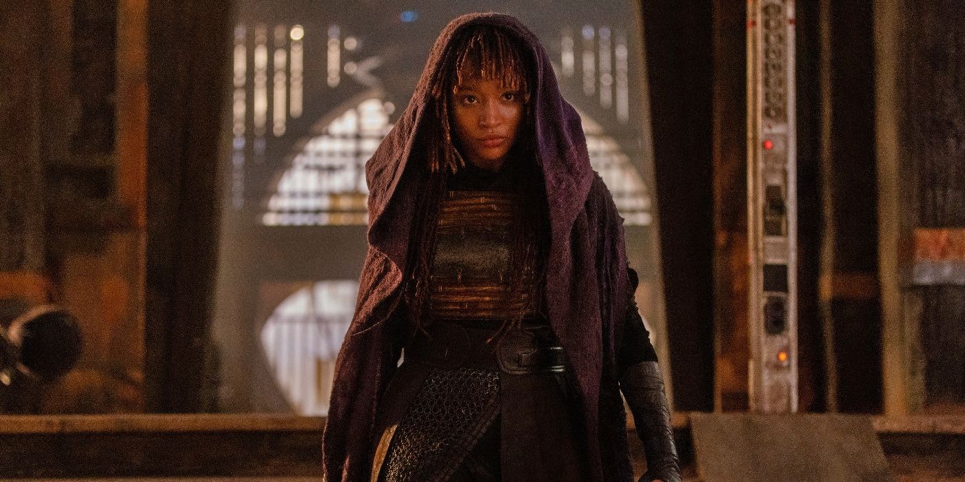 Amandla Stenberg as Mae wearing a purple hooded cloak in The Acolyte