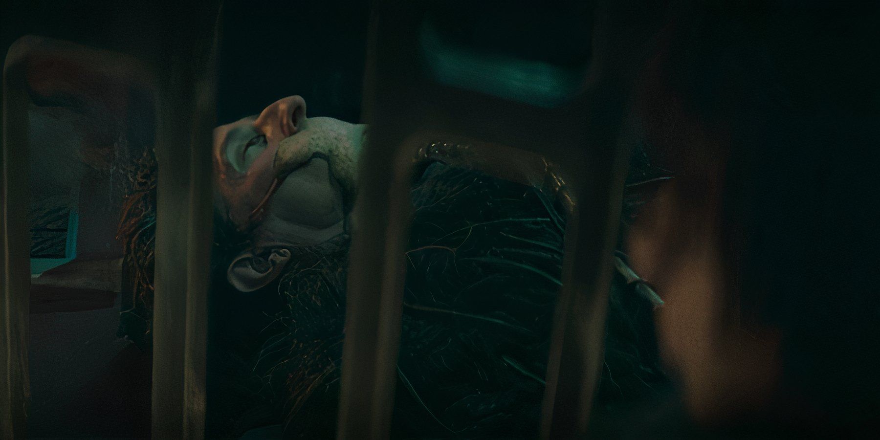 A prisoner behind bars with an alien creature wrapped over his mouth in 'The Acolyte'