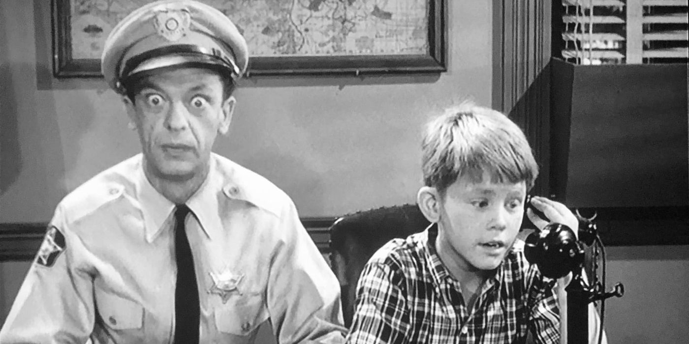 Barney Fife sits with widened eyes next to Opie, who is on a phone in 'The Andy Griffith Show.'