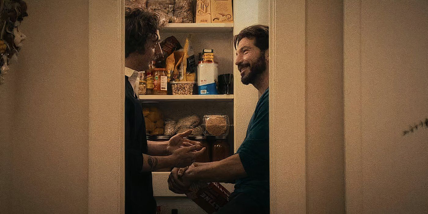 Carmy (Jeremy Allen White) and Mikey (Jon Bernthal) talking inside a pantry and smiling in The Bear Season 2