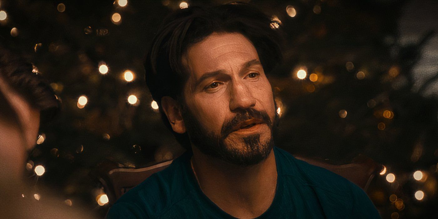 Mikey (Jon Bernthal) sitting at Christmas dinner looking to the right at someone offscreen in The Bear Season 2