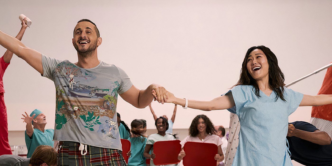 Frenchie and Kimiko holding hands, singing and dancing with others behind them in a scene from The Boys.