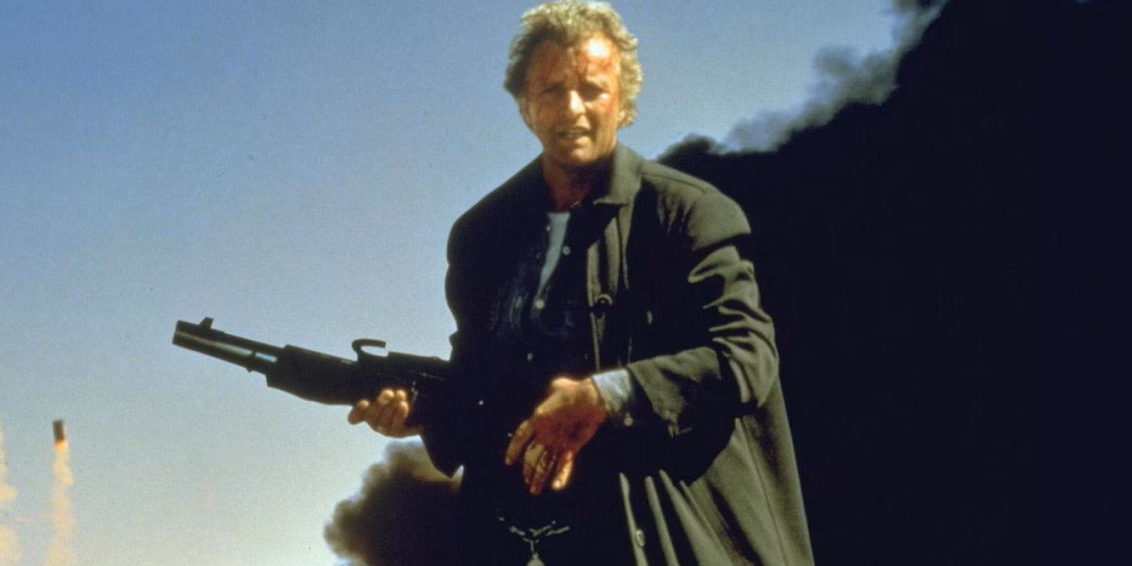 John Ryder (Rutger Hauer) holds a gun as smoke billows behind him in 'The Hitcher'