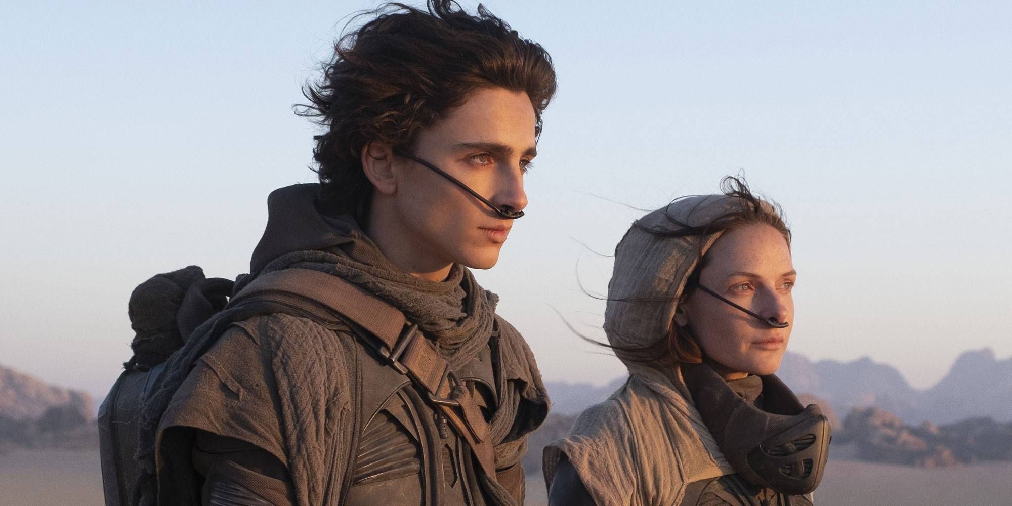 Timothée Chalamet as Paul and Rebecca Ferguson as Jessica in Dune looking at the horizon.
