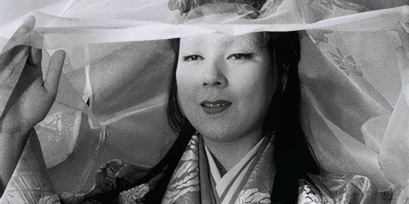 Machiko Kyo as Lady Wakasa lifts a veil from her face