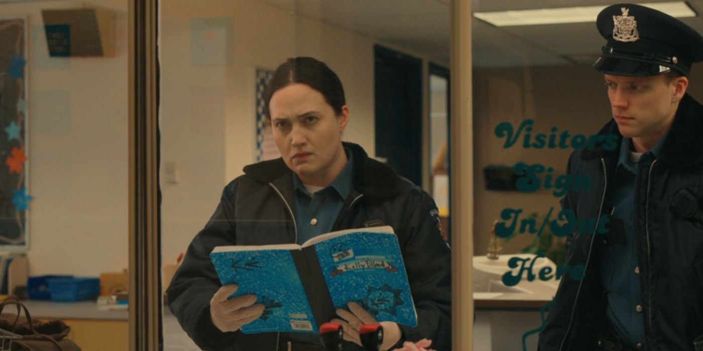 Cam looks up disturbed after looking at a drawing in Kelly's notebook.