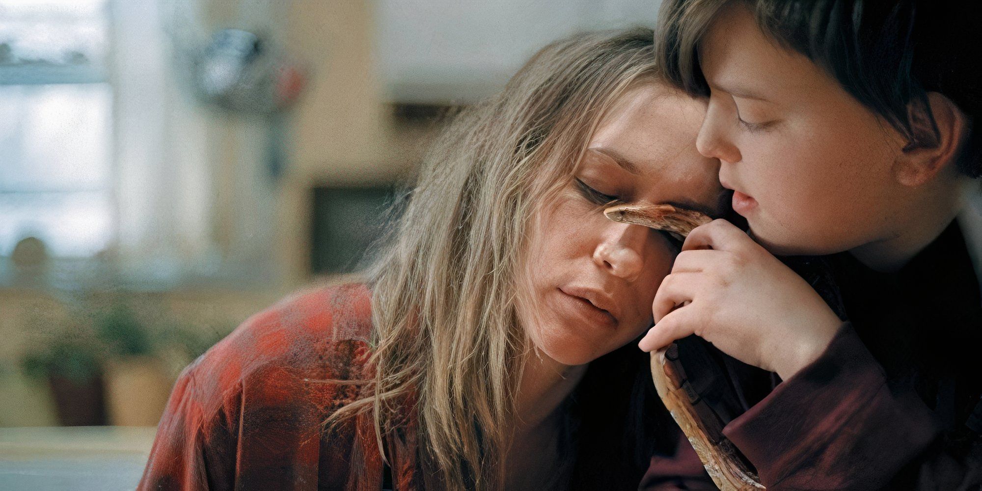 Vera Farmiga as Irene leaning on a boy who&rsquo;s holding a snake in Down to the Bone.