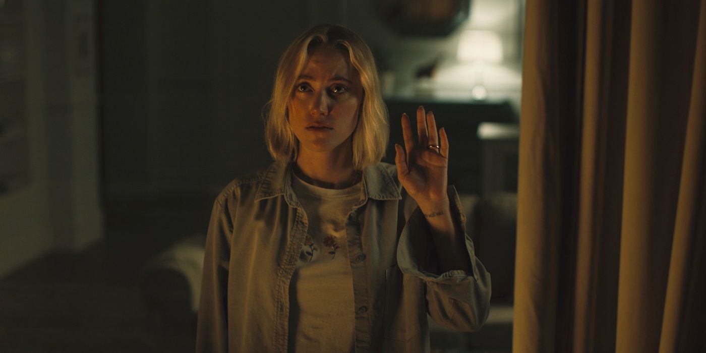 Maika Monroe as Julia waving at a person offscreen in 2022&rsquo;s Watcher