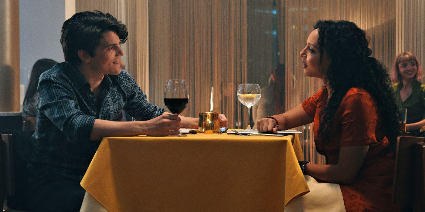 Marcus (Edward Bluemel) and Phoebe (Adelle Leonce) on a date, with Marcus sitting on the left side of the table and Phoebe on the left, both smiling and looking intensely at one another, in A Discovery of Witches