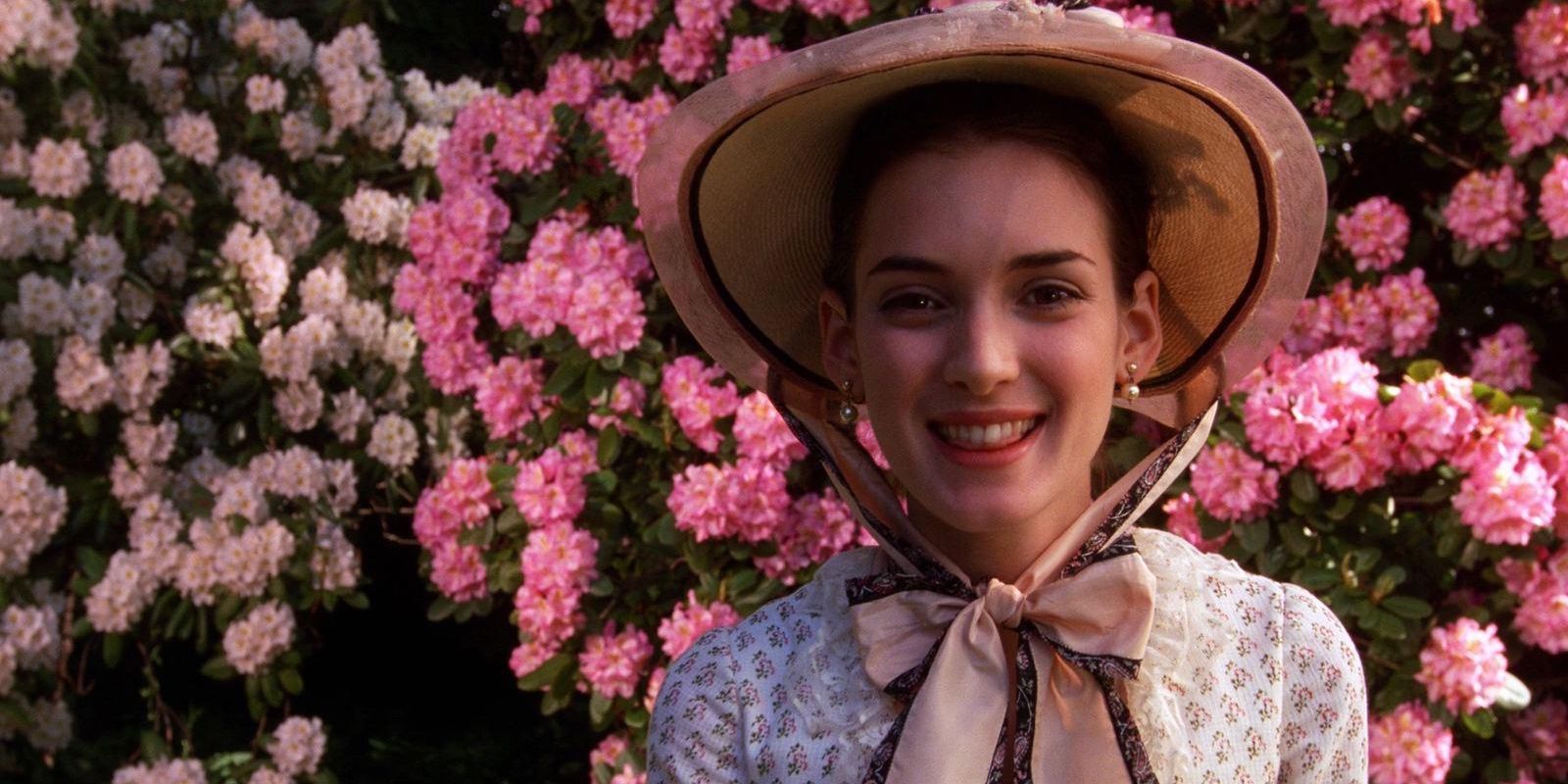 May Welland (Winona Ryder) standing in front of flowers in The Age of Innocence