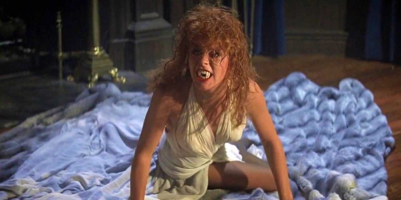 Amanda Bearse with large vampire teeth sitting on a blanket in Fright Night (1985)