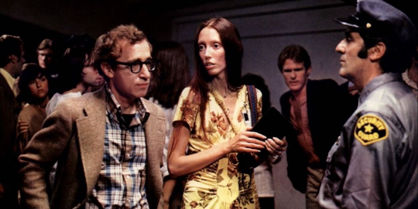 Alvy and Pam, played by actors Woody Allen and Shelley Duvall, stand in a crowd in front of a security guard in Annie Hall.