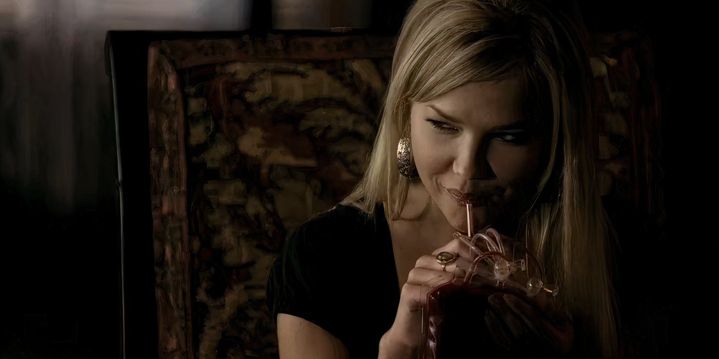 A blonde vampire woman smiles while sipping a blood bag through a straw