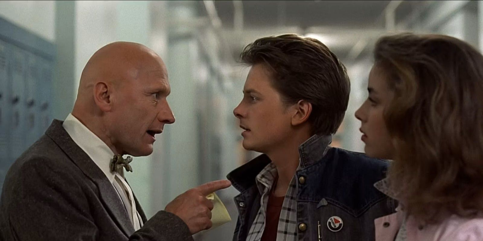 Principal Strickland points at Marty and Jennifer in a school hallway in 'Back to the Future'