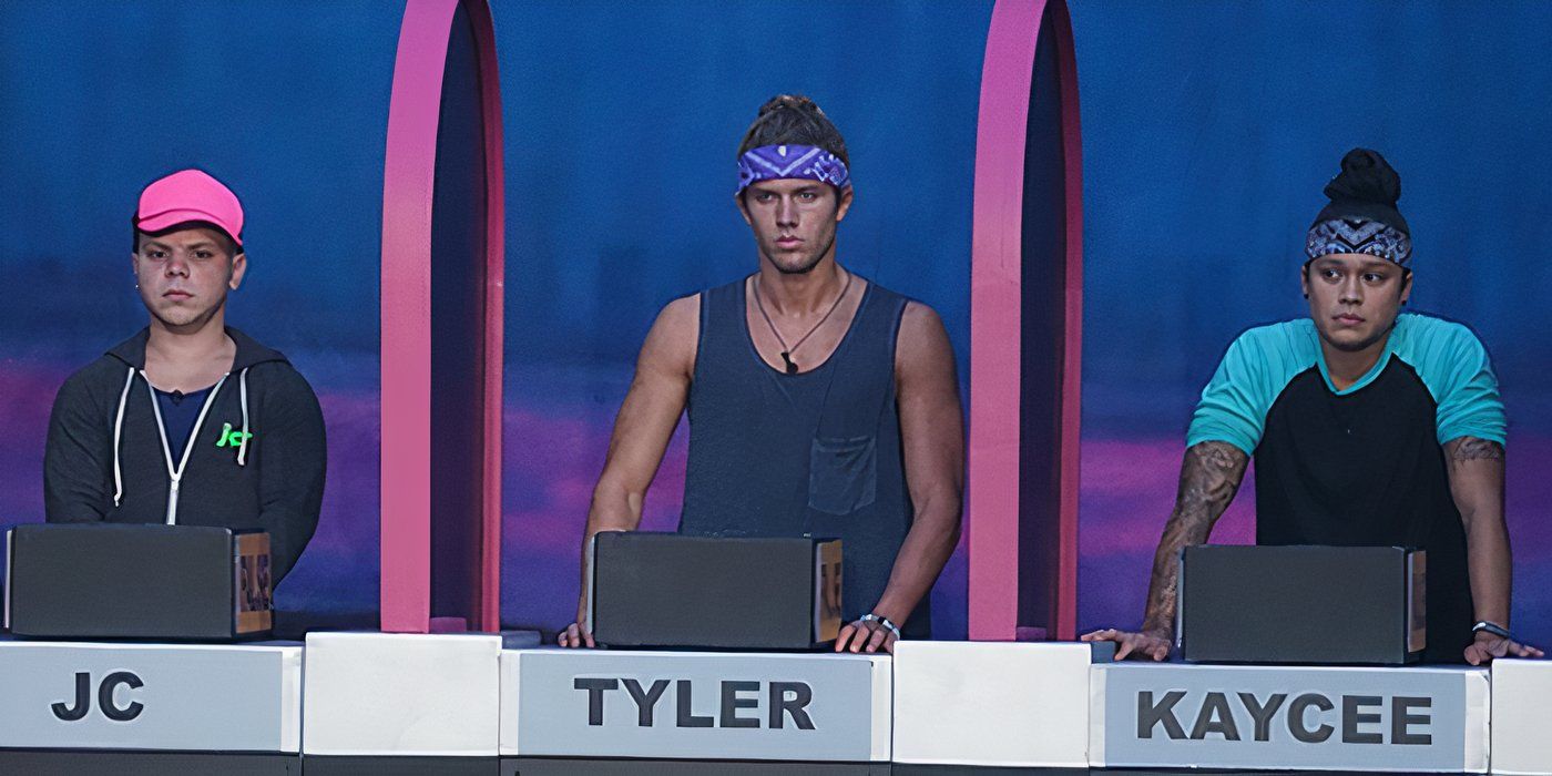 Three players at separate podiums separated by dividers for a quiz competition on Big Brother