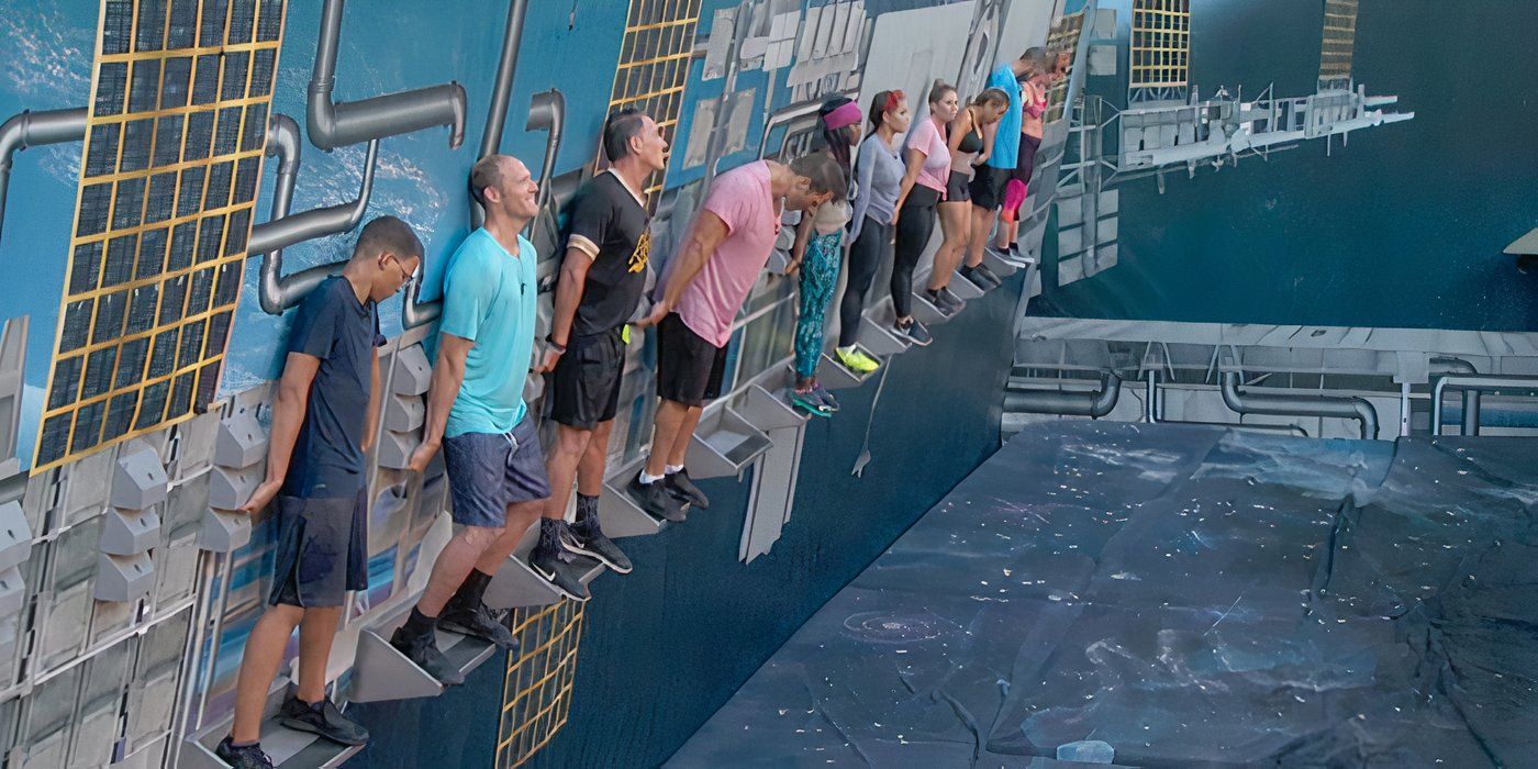 Several players balancing on a leaning wall in The Wall competition on Big Brother