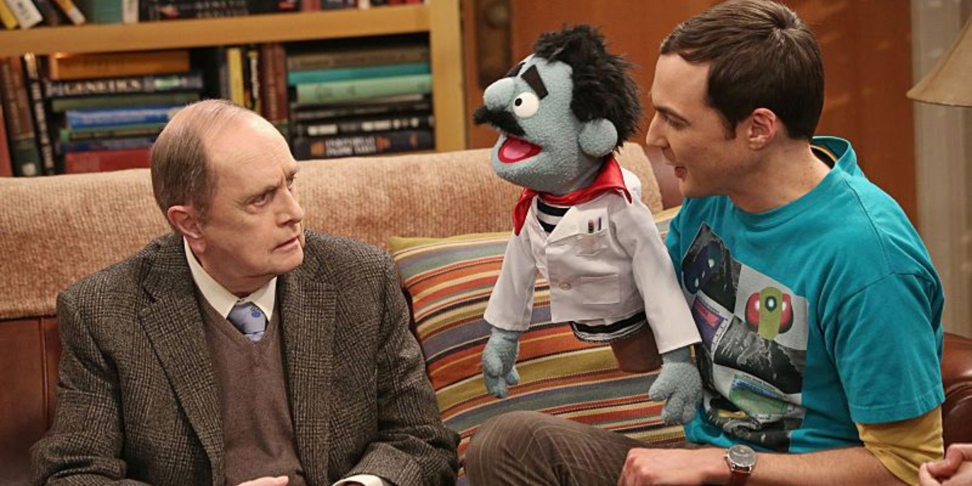 Bob Newhart sentado junto a Jim Parsons, que tiene una marioneta en su mano en The Big Bang Theory