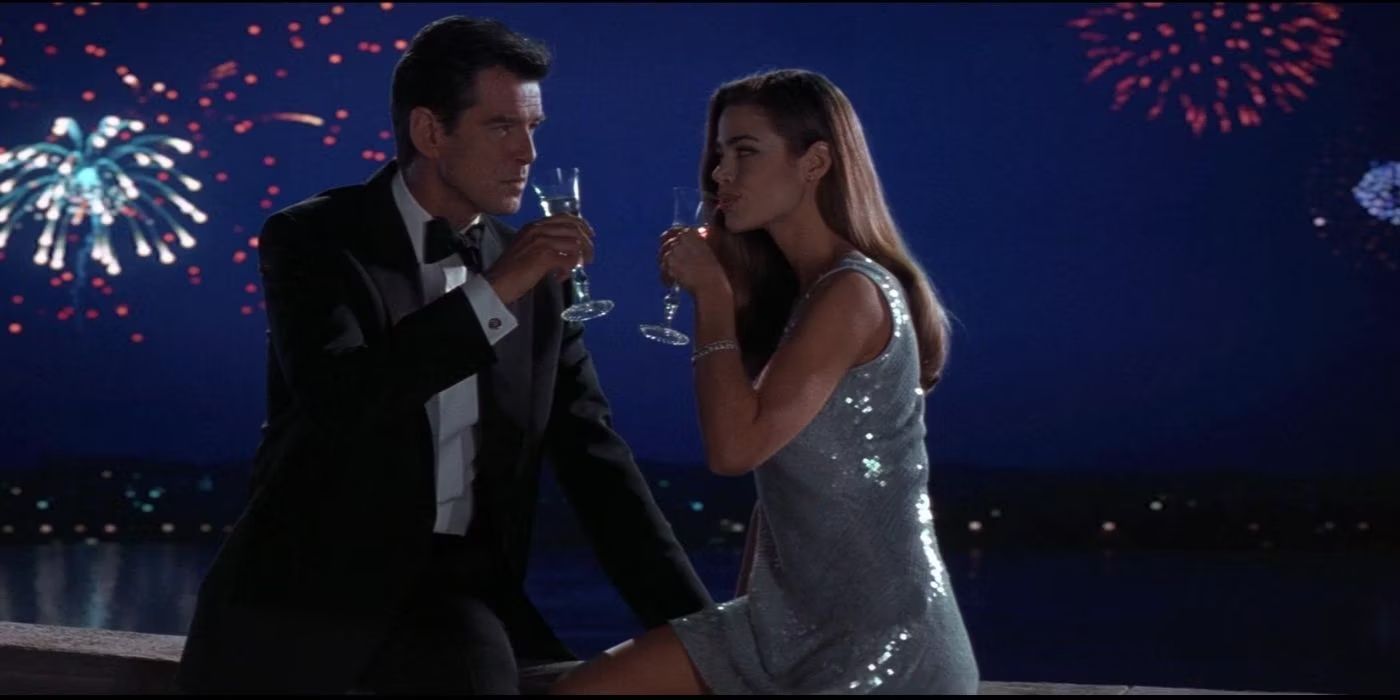 James Bond (Pierce Brosnan) shares a drink with Dr. Christmas Jones (Denise Richards) as fireworks blast in the background in 'The World Is Not Enough' (1999).