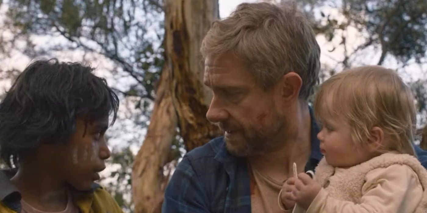 Martin Freeman as Andy holding his baby Rosie while sitting next to Simone Landers as Thoomie in 'Cargo'