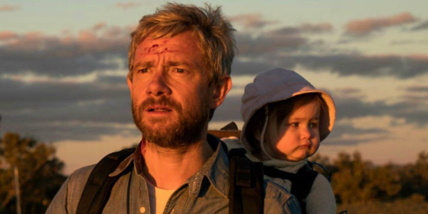 Martin Freeman as Andy looks into the sunset with baby Rosie on his back in a carrier in 'Cargo'