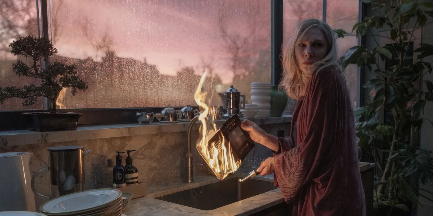 Cate Blanchett holding a newspaper on fire near the sink in 'Disclaimer'.