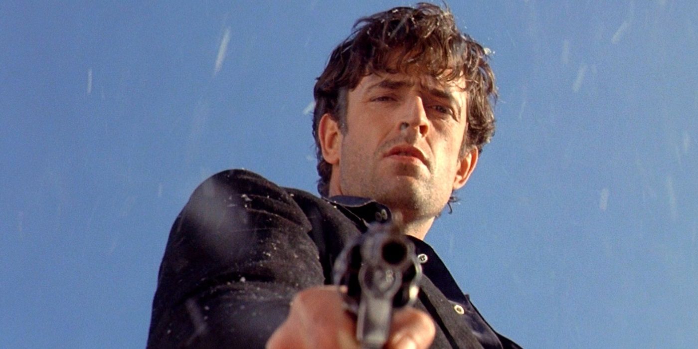 Rupert Everett as Francesco Dellamorte pointing a gun at a target offscreen in Cemetery Man