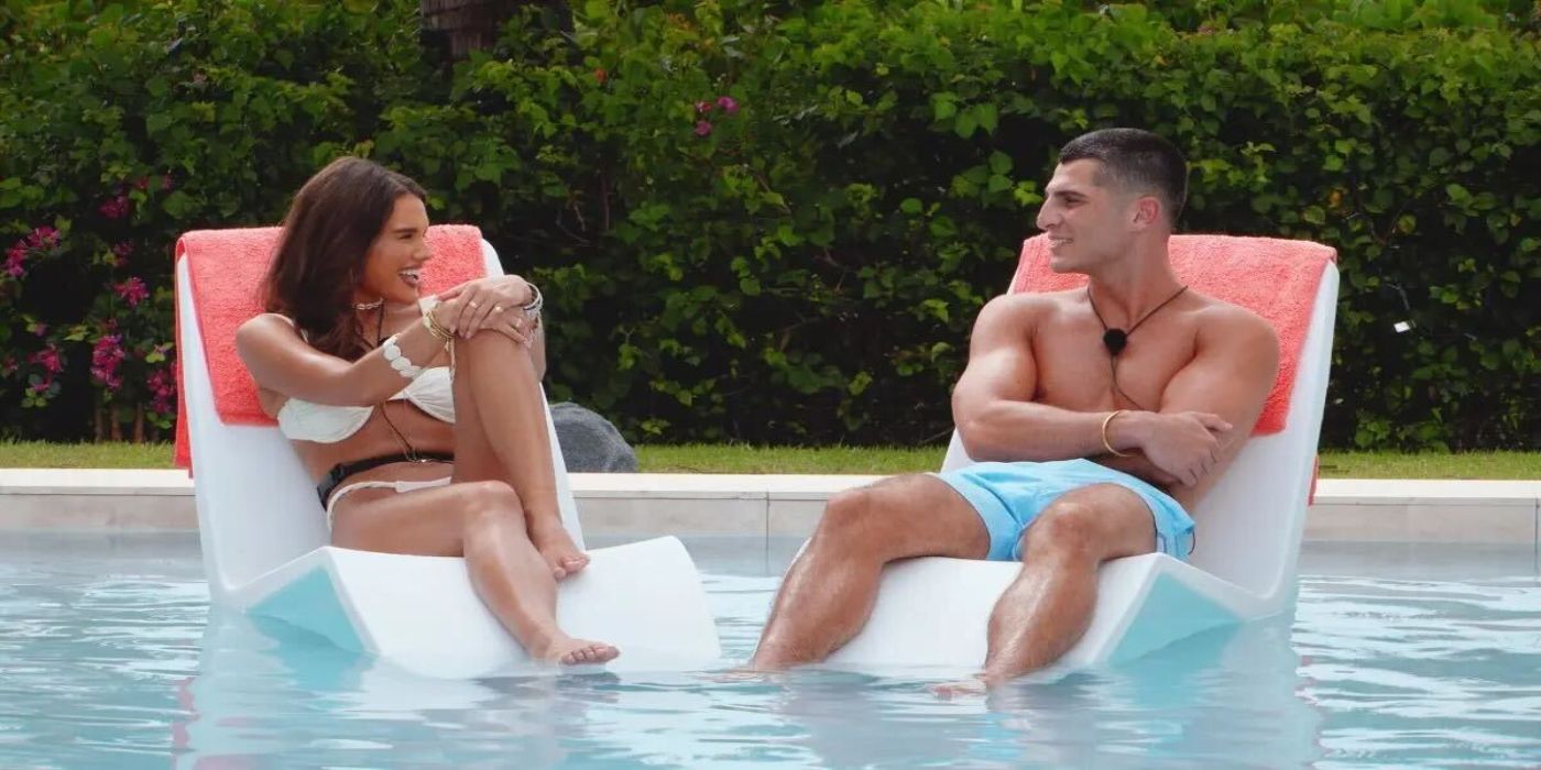 Charlie and Lucy  from Too Hot To Handle Season 6 looking at one another while sitting in chairs in the pool