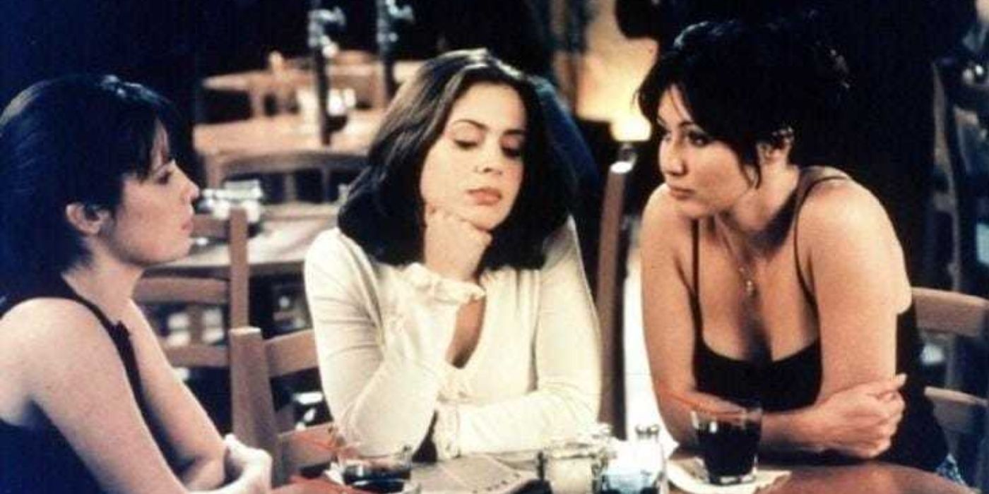 Shannen Doherty, Alyssa Milano, and Holly Marie Combs sitting at a restaurant in Charmed