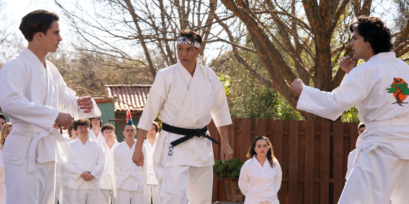 Tanner Buchanan as Robby Keene, Ralph Macchio as Daniel LaRusso and Xolo Maridueña as Miguel Diaz squaring up to fight in Cobra Kai