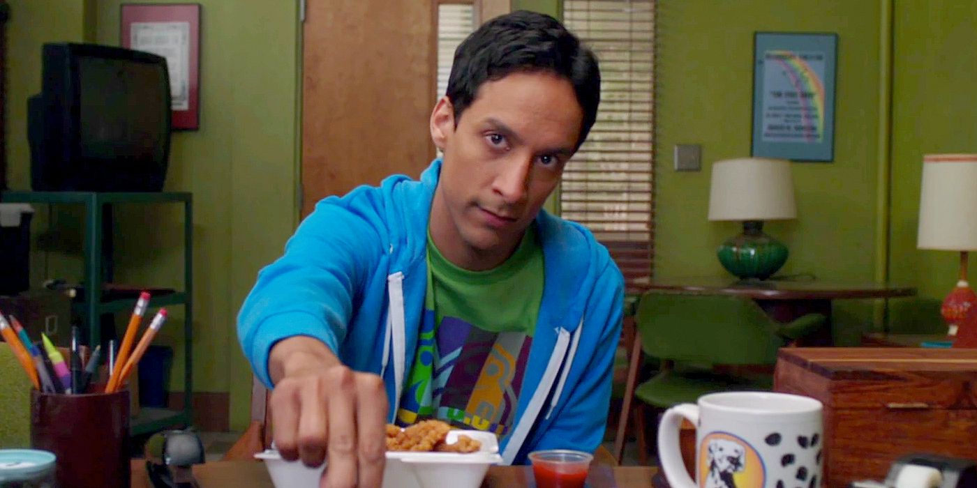 Abed (Danny Pudi) intensely stares at the camera as he offers chicken fingers over a desk)