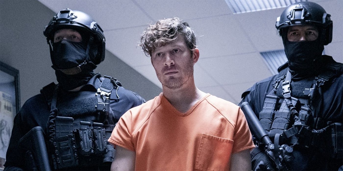 Zach Gilford as Sicarius in an orange jumpsuit with a heavily armed guard on each side of him  in Criminal Minds: Evolution