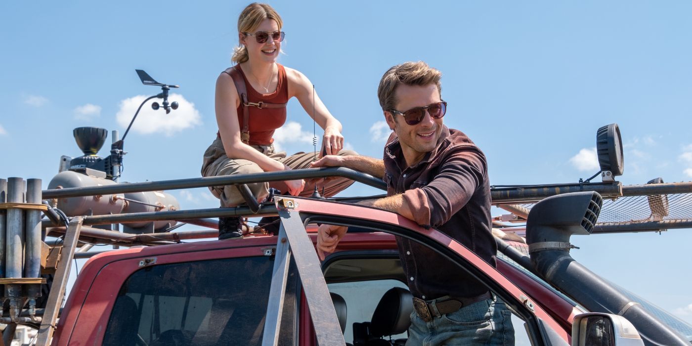 Kate and Tyler wear sunglasses and pose with a stormproof red truck.