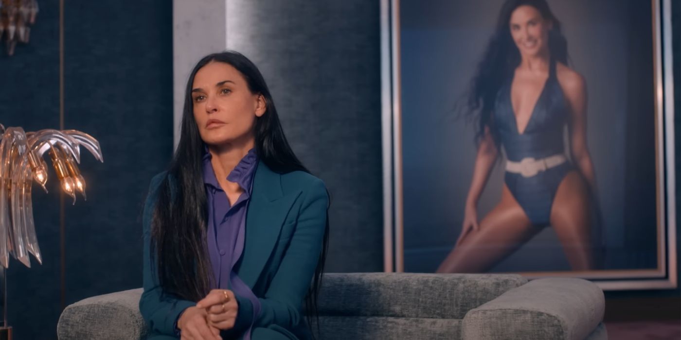 Demi Moore sitting in front of a giant framed portrait of herself in The Substance.