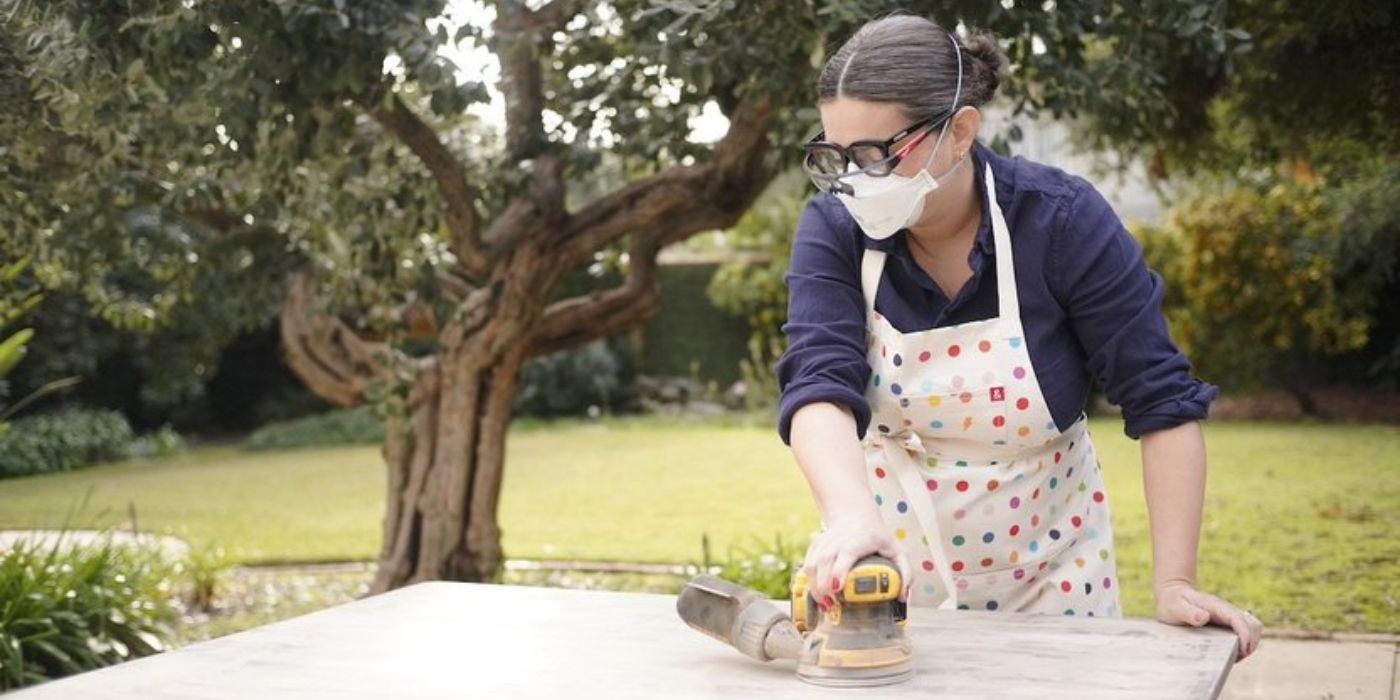 Ellen Bennett pule un trozo de madera al aire libre en 