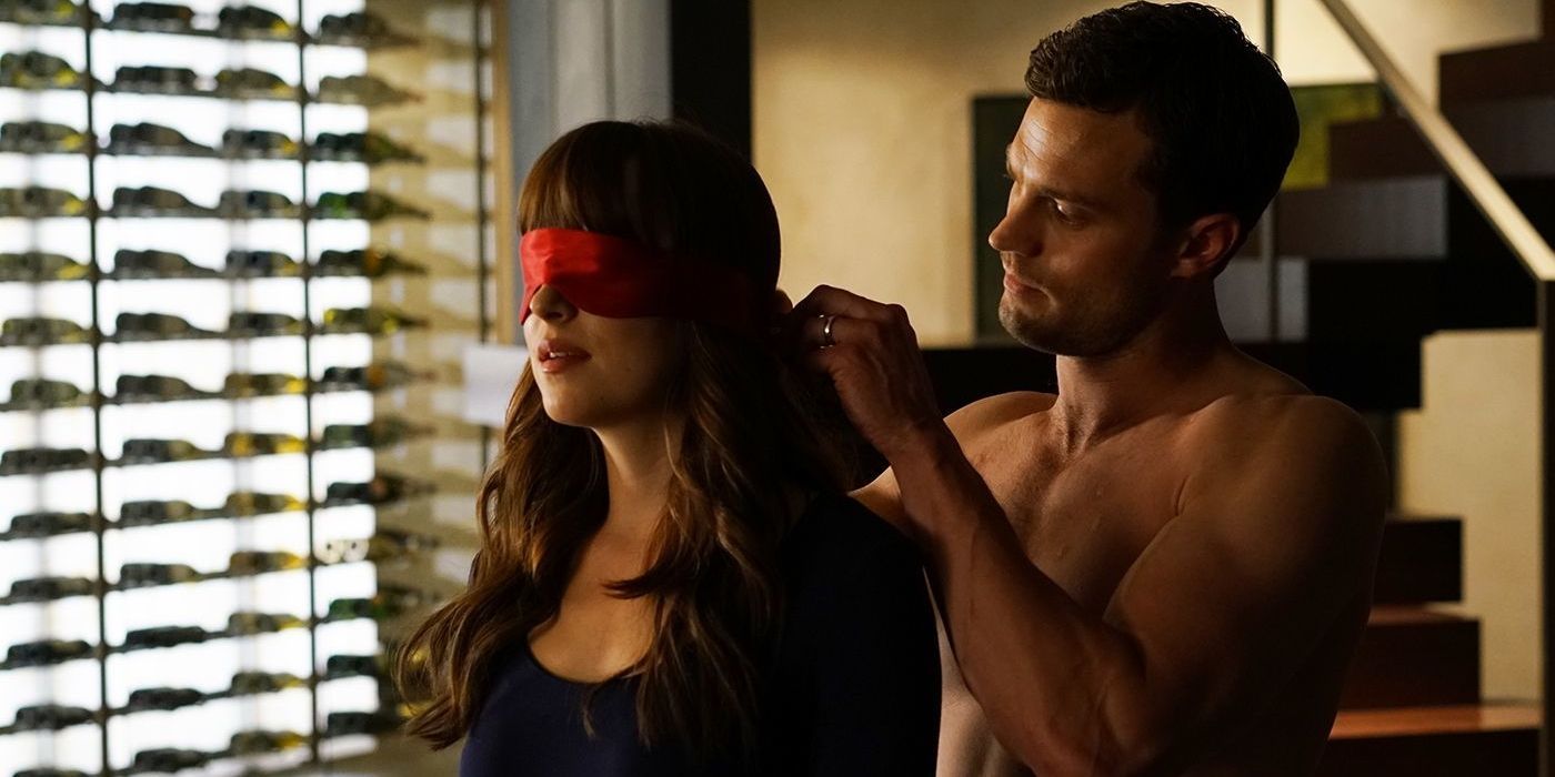 Jamie Dornan as Christian Grey putting a blindfold on Dakota Johnson as Anastasia Steele in Fifty Shades Freed