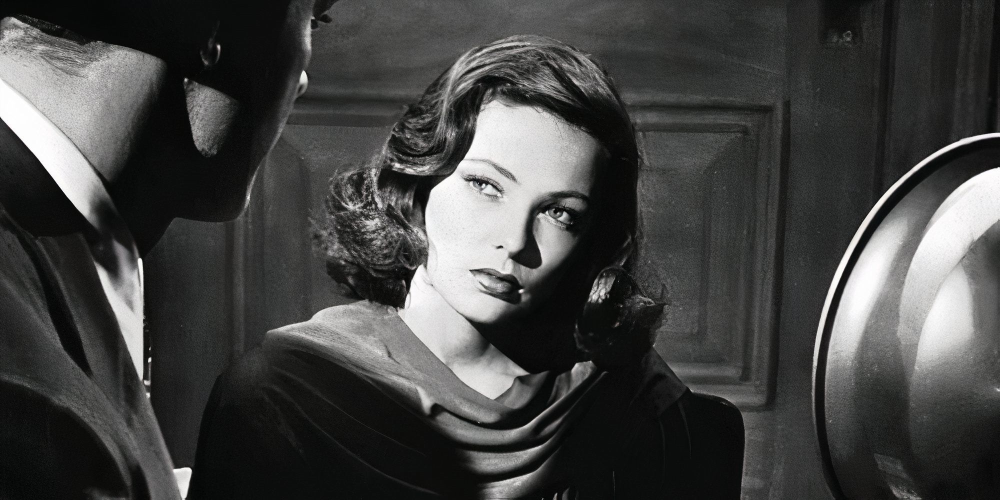 Gene Tierney sitting down looking at someone skeptically in Laura (1944)