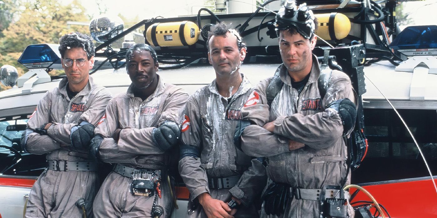 Harold Ramis, Ernie Hudson, Bill Murray, and Dan Aykroyd leaning against the Ectomobile in Ghostbusters