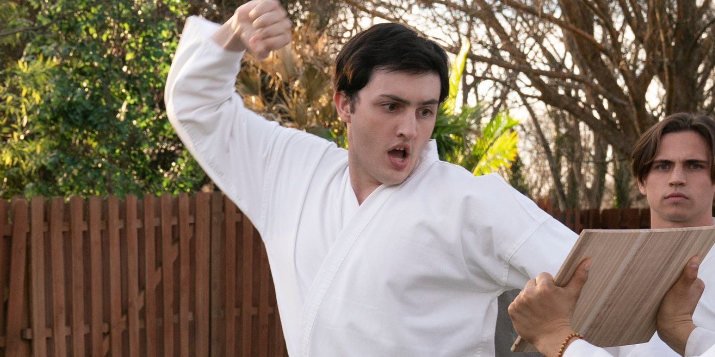 Gianni DeCenzo as Demetri getting ready to punch a wooden board in Cobra Kai Season 6 Part 1.