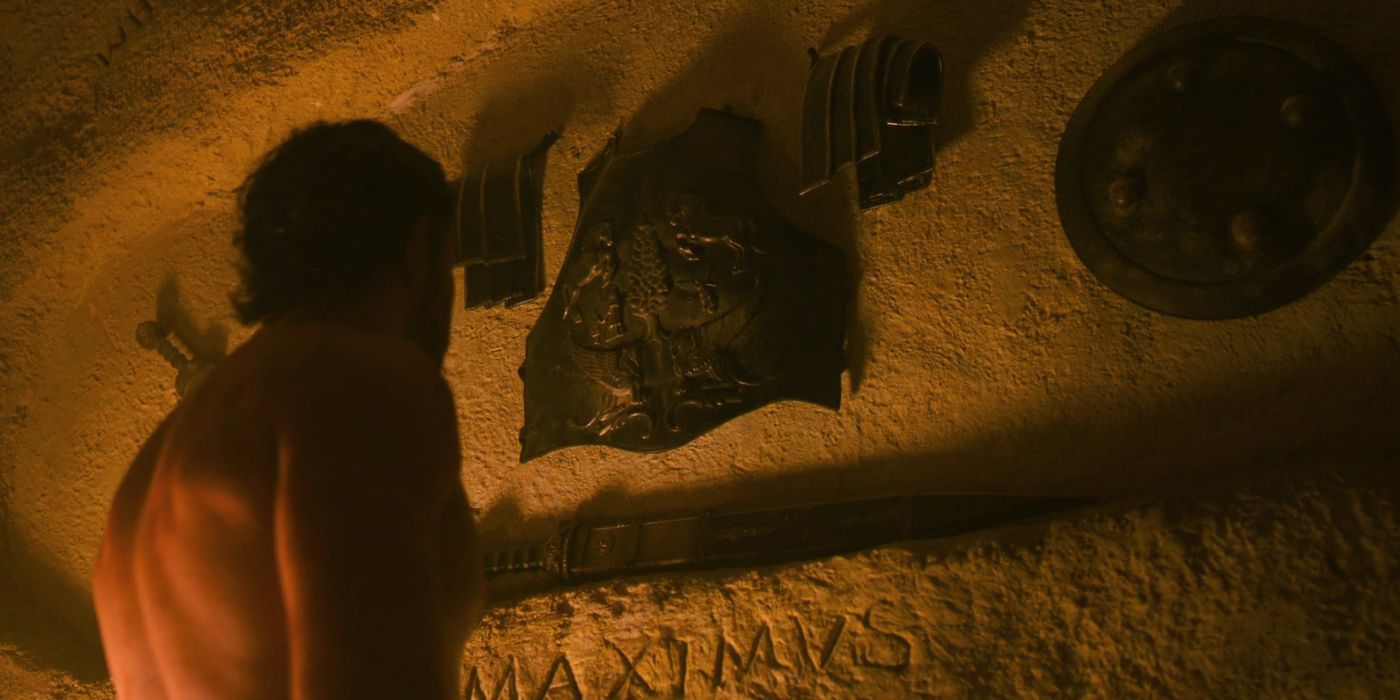 A shirtless Paul Mescal as Lucius with his back turned towards the camera, looking at Maximus' armor in Gladiator 2.